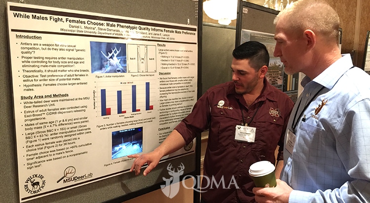 QDMA's Kip Adams (right) talks with Daniel Morina of Mississippi State University about his poster presentation on doe preferences for large-antlered bucks.