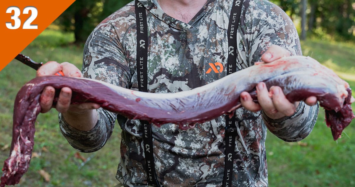Photo of a venison backstrap being held by a hunter in warm weather.