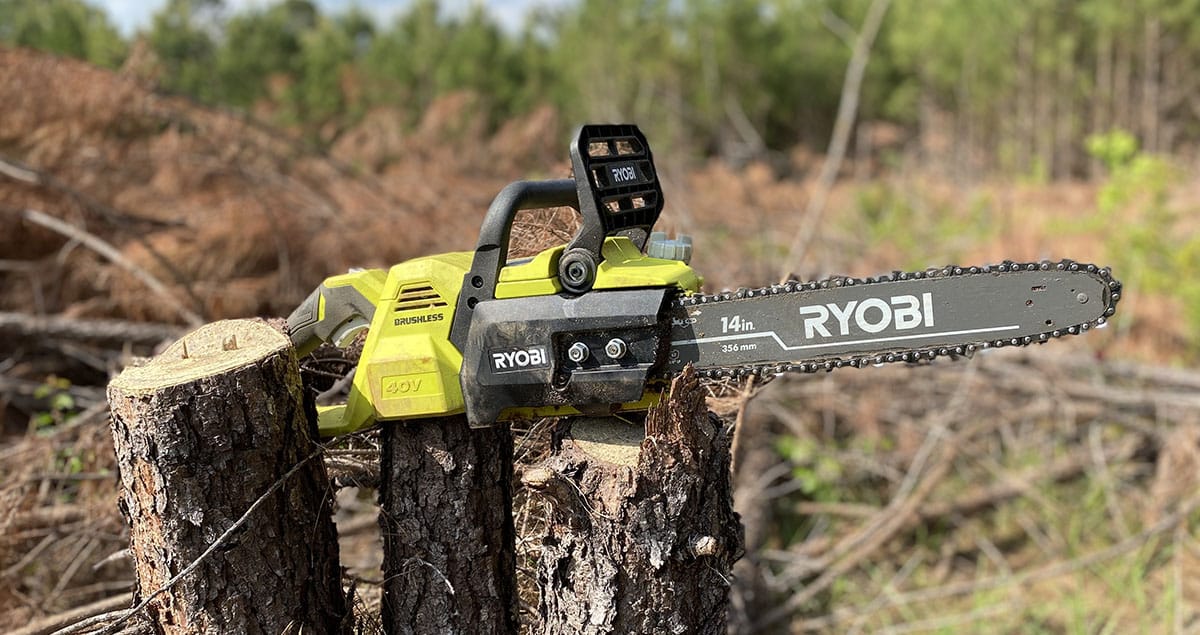 A Ryobi battery powered chainsaw sitting on a pine stump.