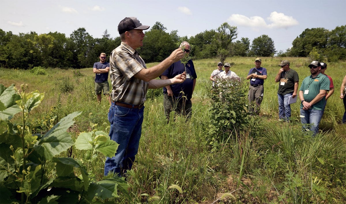 Craig Harper teaching students in a field.