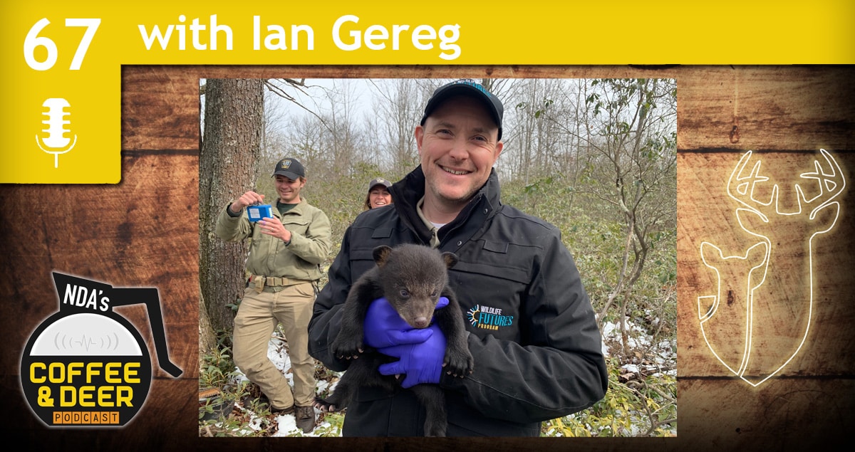 Wildlife health technician Ian Gereg holding a small bear cub.